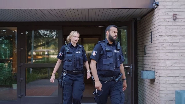 Eine Polizistin und ein Polizist vor einem Gebäude (Quelle: Staatskanzlei) Eine Polizistin und ein Polizist vor einem Gebäude
